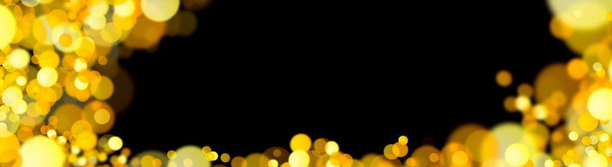 Golden highlights on a black background. Festive background. Blurred golden bokeh on a black background. New Year. Shiny gold glitter particles falling on a black background