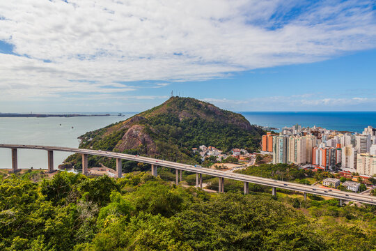 Aerial view of Vila Velha from Convento da Penha on a sunny day, highlighting Praia da Costa and Itapu&atilde; neighborhoods with the blue ocean in the background. Perfect blend of urban and coastal beauty.
