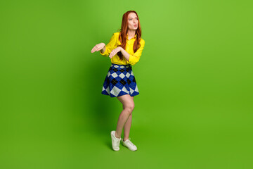 Photo of cheerful carefree adorable woman wear yellow trendy clothes dance look empty space isolated on green color background