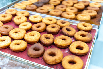 Donut production. The donuts are fried, glazed, and laid out on racks at a donut bakery.