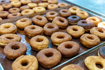 Donut production. The donuts are fried, glazed, and laid out on racks at a donut bakery.