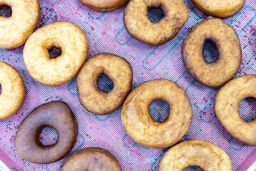Donuts ready to be decorated with icing, donut production process.