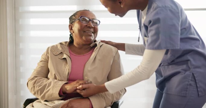 Old woman, wheelchair and caregiver holding hands in nursing home in trust, support or help. Elderly patient, glasses and nurse with talk, assistance and mobility for doctor appointment for health