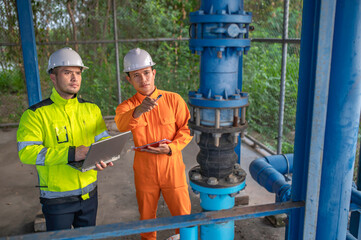 Engineer and technician maintenance checking technical data of system equipment Condenser Water pump and pressure gauge,environmentalist working at water supply