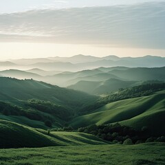 A wide-angle shot of a green mountain landscape at sunrise, with soft light highlighting the rolling hills and valleys