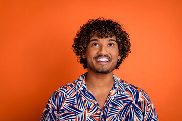 Photo portrait of handsome young man look up empty space dressed stylish colorful garment isolated on orange color background