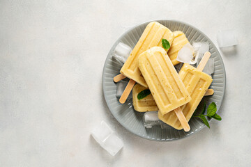 Homemade fruit yellow popsicles with mango, banana, pineapple. Top view. 