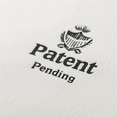 A sophisticated black stamp imprint with the words "Patent Pending" in classic, serif font, stamped on crisp white paper. The design features a subtle emboss effect and clean lines, suggesting legal f