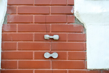 striking image showcases concrete weights mimicking dumbbells, bridging a cracked brick wall. It...