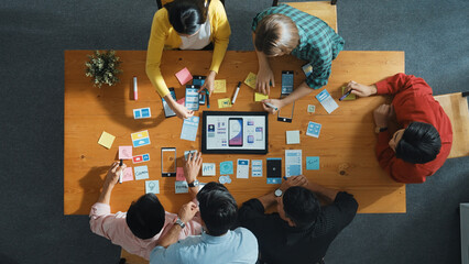 Top view of software developer team looking Ux Ui design for mobile phone interface from tablet...