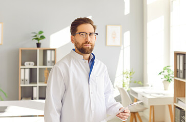 Obraz premium Male doctor professional portrait, medical assistant working in office, wearing glasses, consulting. Man performing medical job, consultant, healthcare administration, clinic management public health