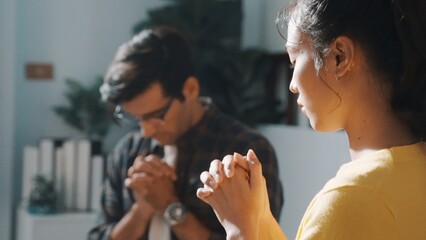 Top view of skilled diverse prayer clasping hand and praying to god while sitting at chair in circle. Top down aerial view of people folded hand while sitting with opened bible on laps. Symposium.