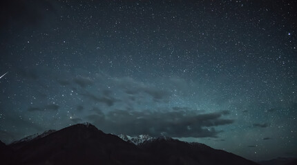 Night landscape in the Tien Shan mountains in Tajikistan in the Pamirs, stars and mountains with snow in the Wakhan Valley