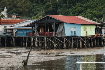Fishing village houses over the water garbage poor areas in Sabah province in Malaysia