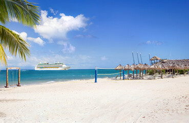 View from tropical beach with active recreation on cruise ship sailing from port 