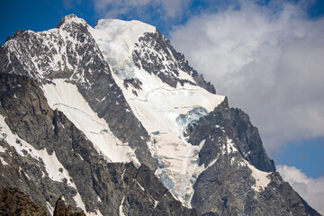 view of a small melting glacier covered with snow and brown sahara dust on the mont blanc in summer...