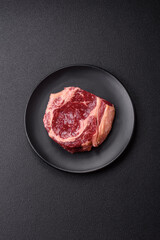 Fresh, raw beef steak with salt, spices and herbs