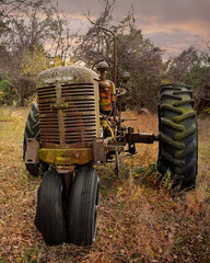 Old vintage farm tractor in a rural landscape