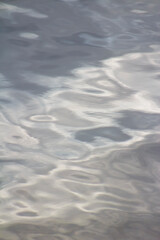 Obraz premium Illuminated Silvery Gray Ripples of Lake Water - Serene, Peaceful, Calm, Spa Like Feel - Backdrop, Background, Wallpaper, Border - metallic look (filtered photo)