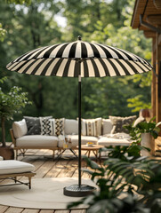 Fototapeta premium Patio with striped umbrella, outdoor seating, and greenery.
