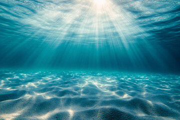 Underwater view of sandy sea bottom with sun rays coming through clouds