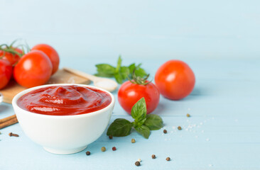 Delicious ketchup with spices and tomatoes on wooden table