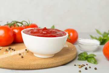 Delicious ketchup with spices and tomatoes on wooden table