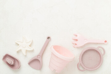 Cute toys for playing with sand on concrete background, top view