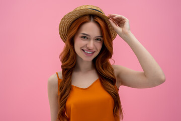 Pretty flirty young woman in straw hat looking contented