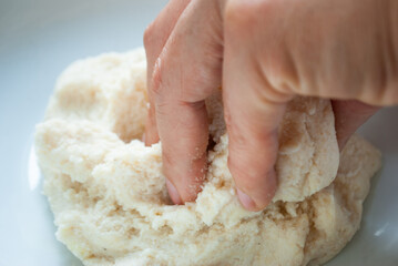woman kneading corn flour inside a bowl