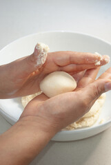 woman kneading corn flour inside a bowl