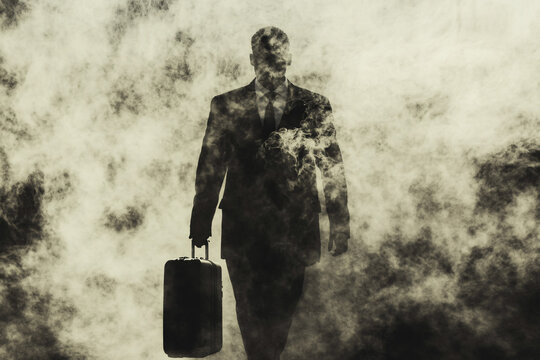man’s silhouette with a briefcase emerges through a dense smoky haze creating a mysterious and eerie atmosphere