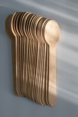 Stack of wooden disposable spoons in sunlight
Close-up of a neatly stacked set of wooden disposable spoons, with soft sunlight creating shadows and highlighting their texture.

