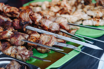 barbecue on skewers on tray in counter in street, grilled meat, street food concept