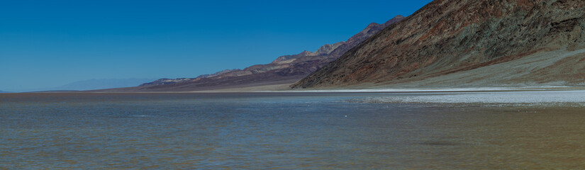 Brine and mountains at Lake Manly in Death Valley National Park after a rainy spring