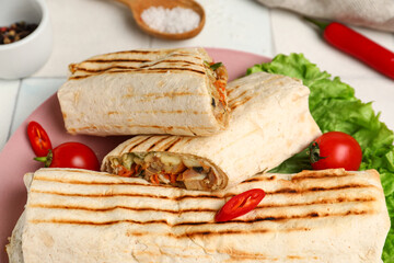 Plate of tasty shawarma with lettuce and tomatoes on white tile table, closeup