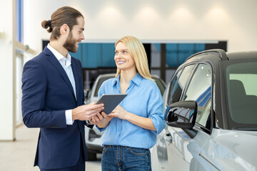 Woman negotiating car purchase with the dealer at automobile store