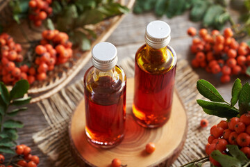 Wild rowanberry syrup in two glass bottles