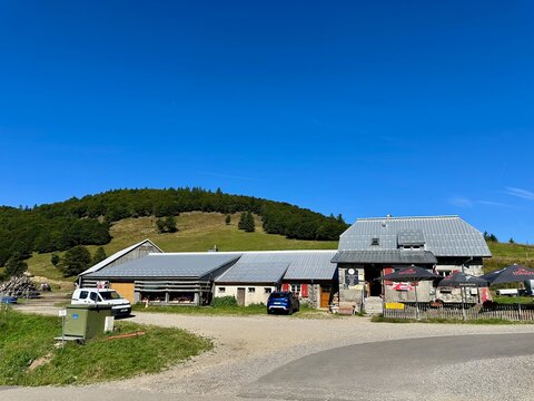 Lautenbach-Zell, France - August 11 2024 : Close-up of the Ferme Auberge at Col du Haag with its rustic architecture set against green hills and clear blue sky, highlighting rural life in Alsace
