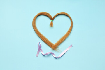 Heart made of red hair strand for donation and purple awareness ribbon on blue background