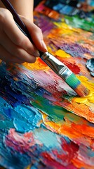 Fototapeta premium A close-up of an art teacher's hands mixing paint on a palette, showcasing vibrant colors