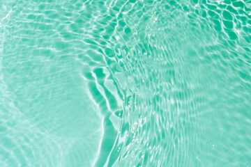 Blue water with ripples on the surface. Defocus blurred transparent blue colored clear calm water surface texture with splashes and bubbles. Water waves with shining pattern texture background.