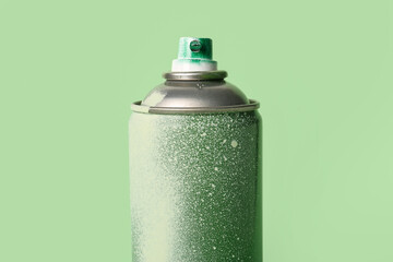 Spray paint can on green background