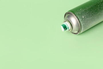 Spray paint can on green background