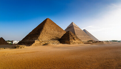 エジプトのギザにあるピラミッド群を広大な砂漠の中で捉えたものです。複数のピラミッドが連なり、夕暮れ時の柔らかな光がその壮大さと神秘性を強調しています。背景には澄んだ青空が広がり、ピラミッドの古代の威厳を一層引き立てています。generative AI