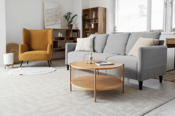 Interior of living room with grey sofa, armchair and window