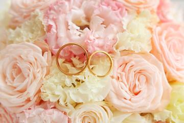 Beautiful wedding rings on bride's bouquet, closeup