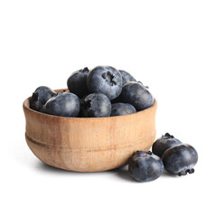 Wooden bowl of ripe blueberry on white background, closeup