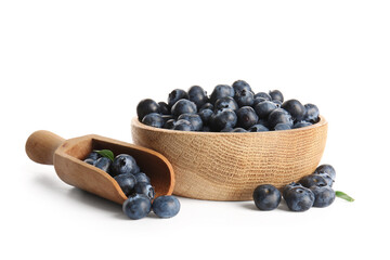 Wooden bowl and scoop with ripe blueberry on white background, closeup