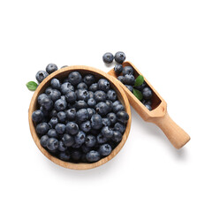Wooden bowl and scoop with ripe blueberry on white background, closeup
